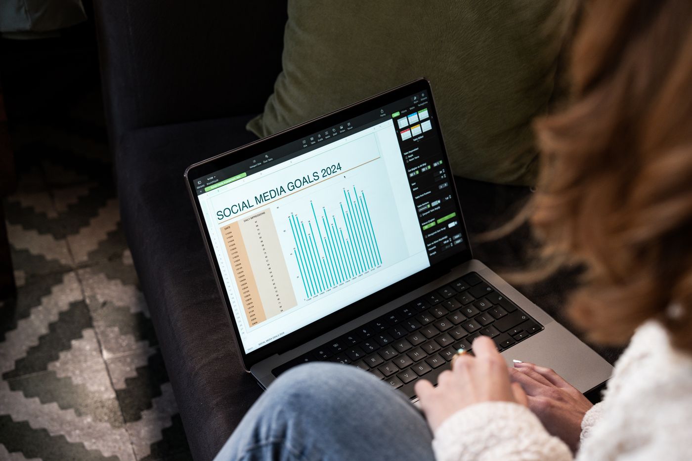 A woman reviewing 2024 social media goals on a laptop at home.