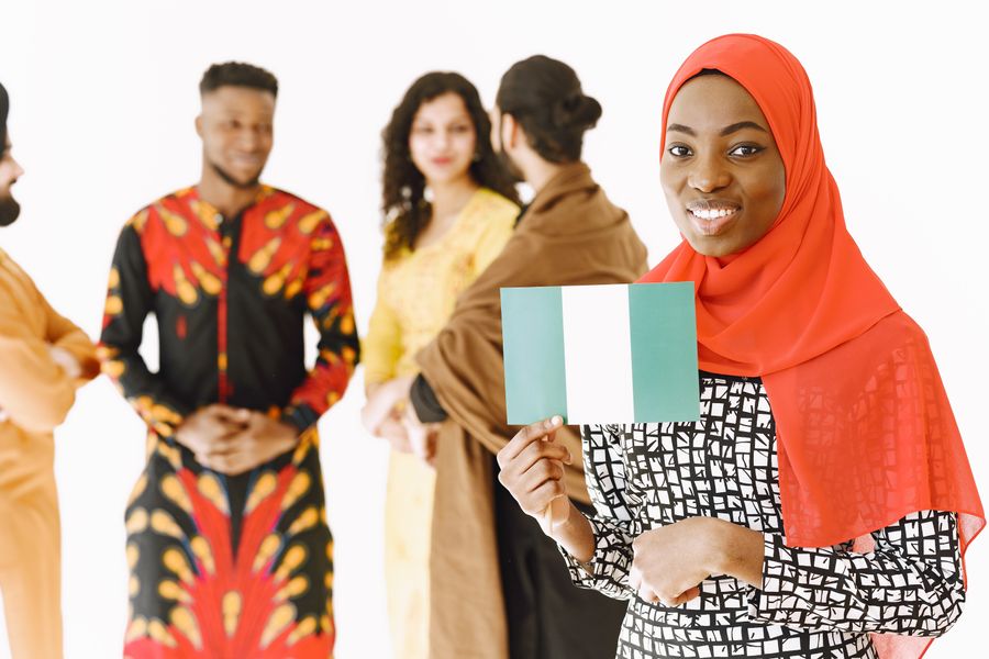 A diverse group of people in traditional attire celebrating in a studio setting.